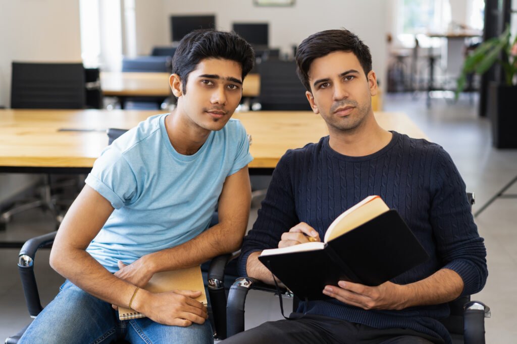 two serious fellow students studying and looking at camera
